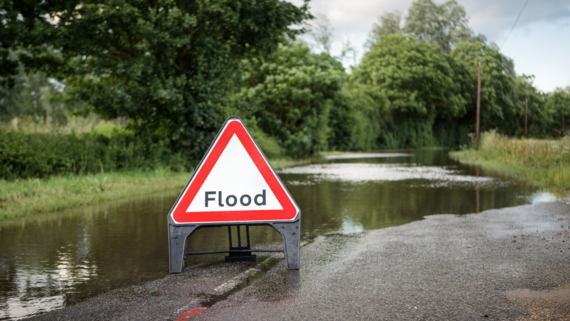 Flooding warning sign on a flooded road