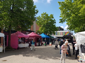 People looking around stalls at the market in Beeston Square