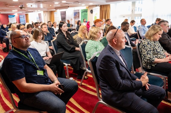 People sat in rows at conference listening to talk