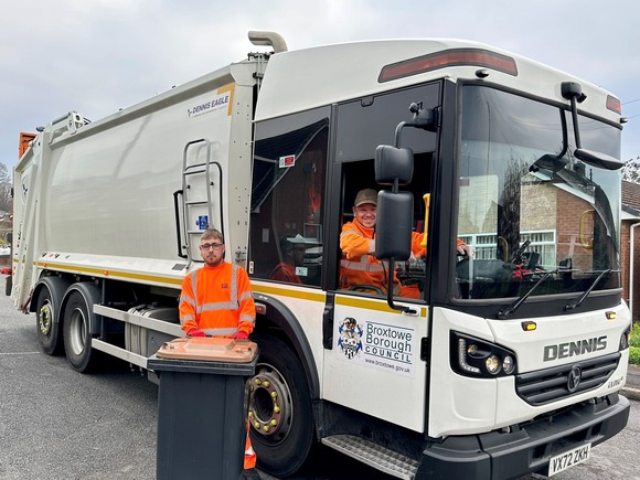 garden waste collection team in refuse vehicle with brown lidded bin