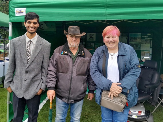 Smiling people in front of green gazebo