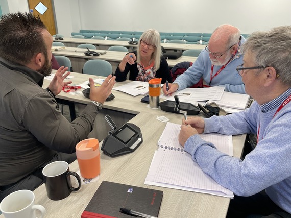 people sitting at table discussing the documents they have been provided