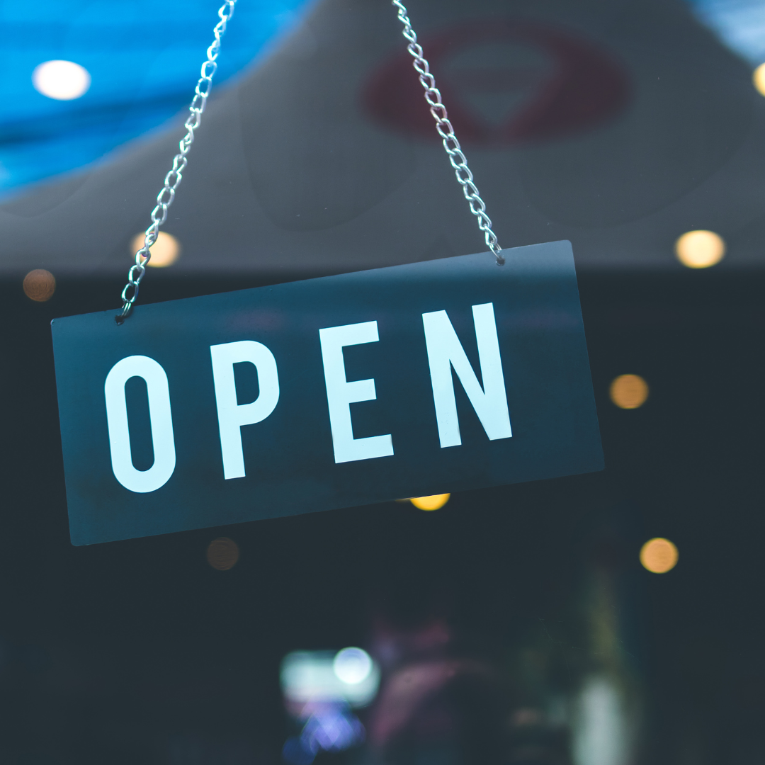 'Open' sign hanging in a shop window