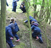 Children exploring the woods during a Forest School class.