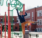 Young child playing on a climbing frame.