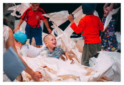 Children playing with a large quantity of paper