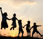Image of a group of children holding hands and jumping