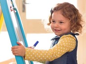 Young child marking an easel