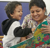 An adult and a young child reading together