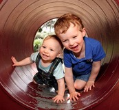 Young children climbing through a tube