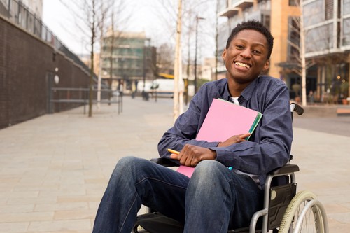 Boy in wheelchair holding folders