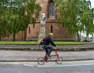 Photo of a man on a bike passing Carlisle Citadel