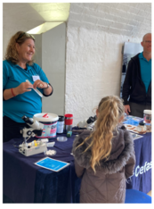 a few people standing around a stand talking