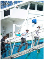 people going over a bridge onto a ship