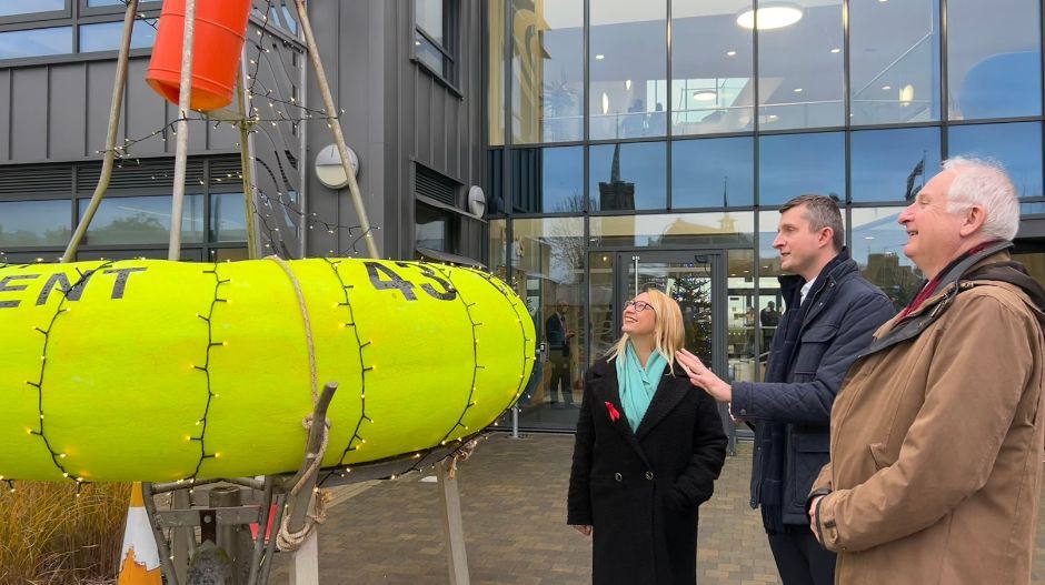 people looking at a smart buoy