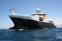 The large research ship James Cook sailing on a calm, blue sea. 