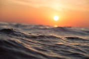 Sun setting with waves in the foreground