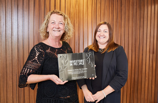 Louise Smyth and Aimee Symonds of Companies House holding the IiP trophy. 