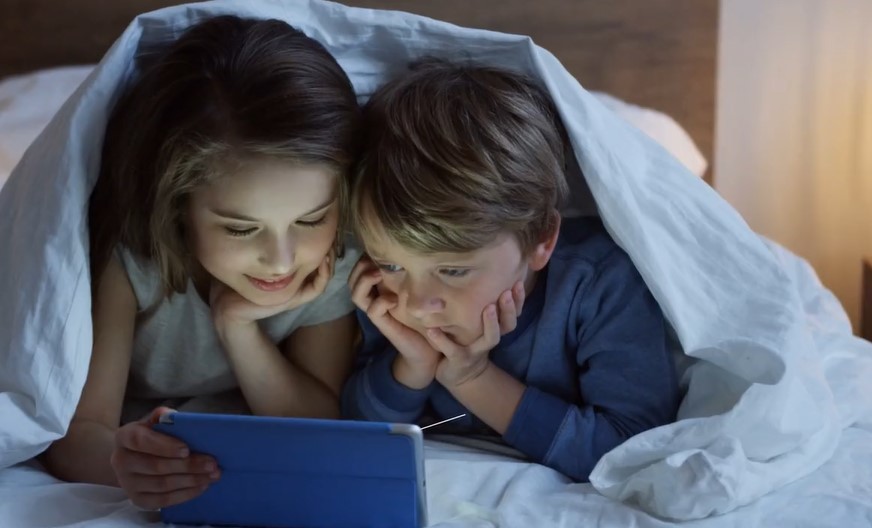 Two children watching a tablet screen