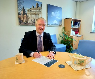 Leader signing UK100 pledge