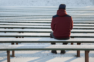 Man sitting alone on a bench in the winter