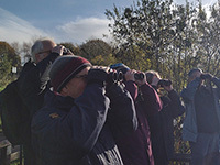 Group of birdwatchers looking through binoculars