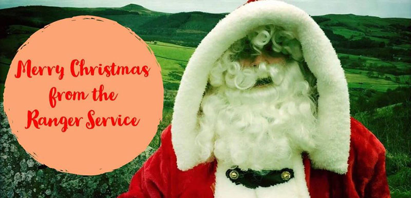 Father Christmas in the Countryside with a 'Merry Christmas from the Ranger Service' speech bubble