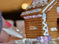 Someone decorating a gingerbread house