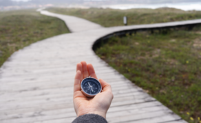 Compass held out at a fork in the path