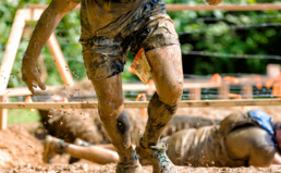 Competitor at a muddy obstacle course
