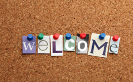 The word welcome spelled out on a cork board