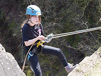 Girl abseiling down a rock face