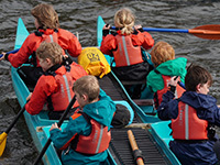 Children canoeing in a large multiperson canoe