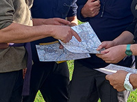 Closeup of several people gathered round a map