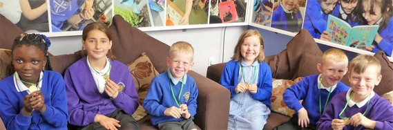 Six children smile at camera holding their medals