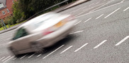 Blurred photo of car on road implying speed