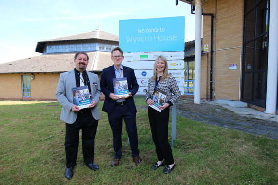 Skills and Employment team Three people stand on grass holding documents