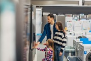 Mum, Dad and child looking at a fridge in a shop