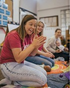 Koala North West employee smiling and clapping in a baby session