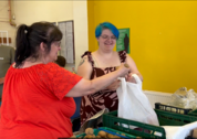 Mum and daughter collecting food from The Bread and Butter Thing hub