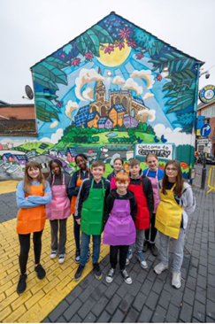 Children with a giant mural in the background