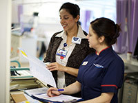 Two nurses looking at file