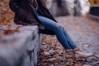 Young person sitting on wall