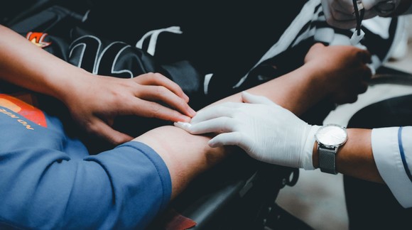 Professional preparing to take blood from a patient