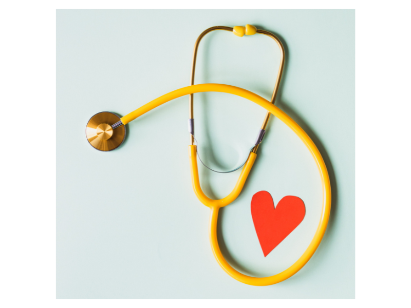 Yellow stethoscope and red paper heart 