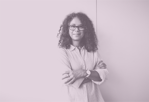 Photograph of a person smiling, arms crossed, against a plain light background.