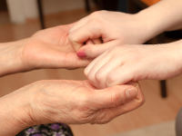 An older person and a younger person holding hands