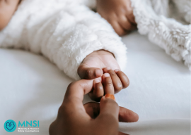 Image of hand stroking a babies face