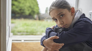 young girl along sitting on floor near doorway