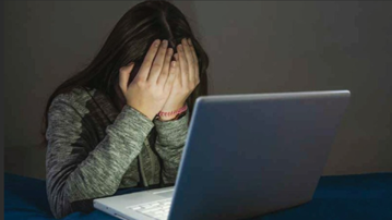 Female with head in hands in front of laptop